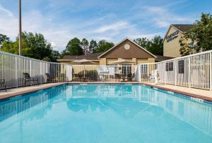 una piscina con una valla y un edificio en Homewood Suites by Hilton Montgomery - Newly Renovated, en Montgomery