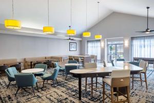a dining room with tables and chairs and windows at Homewood Suites by Hilton Montgomery - Newly Renovated in Montgomery