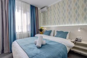 1 dormitorio con 1 cama grande con almohadas azules en Viva Hotel, en Bishkek