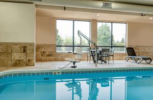 a swimming pool with chairs and a table and a tablektop at Hampton Inn Washington Court House in Jeffersonville