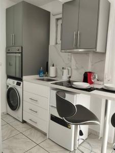 a white kitchen with a stove and a dishwasher at Kentrikon Guest House in Xanthi