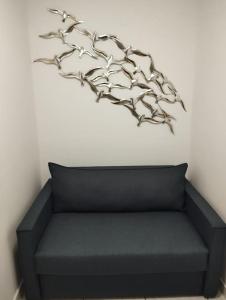 une branche sur le mur au-dessus d'un canapé dans l'établissement Kentrikon Guest House, à Xánthi
