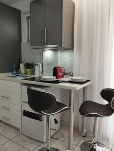 una piccola cucina con due sedie e un tavolo di Kentrikon Guest House a Xánthi