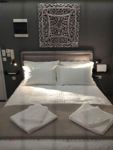 Una cama blanca con dos toallas blancas. en Kentrikon Guest House, en Xanthi