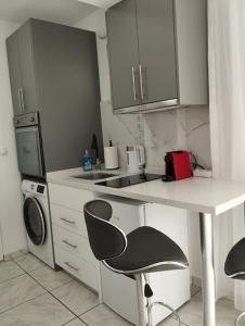 a kitchen with a table and a chair and a microwave at Kentrikon Guest House in Xanthi