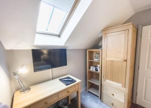 a room with a desk and a tv and a window at The County in Newton Aycliffe
