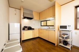 a kitchen with brown cabinets and a white microwave at VILLA MorE in Tokyo