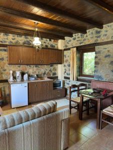 a kitchen with a couch and a table in a room at Suites Mouses in Palaios Agios Athanasios