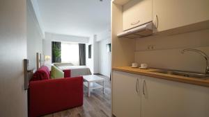cocina con silla roja y sala de estar en Olympus Thalassea Hotel, en Paralia Katerinis