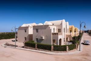 Makadi Heights Elite Residence - Hurghada, Red Sea في الغردقة: منزل أبيض كبير في موقف للسيارات