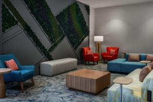 una sala de estar con muebles coloridos y una gran pintura en Hilton Garden Inn Tewksbury Andover, en Tewksbury