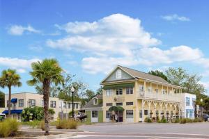 a building with palm trees in front of a street at Travelodge by Wyndham Kingsland GA in Kingsland