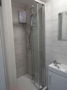 a bathroom with a shower and a sink at The Old Guest House, Norbury Avenue in Norbury