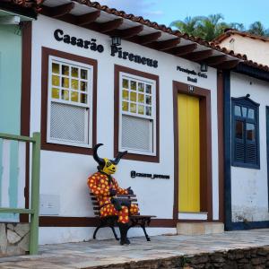 a statue sitting on a bench in front of a building at Casarão Pireneus in Pirenópolis