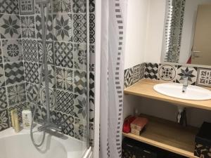 ein Bad mit einer Dusche und einem Waschbecken in der Unterkunft Appartement très lumineux in Égat