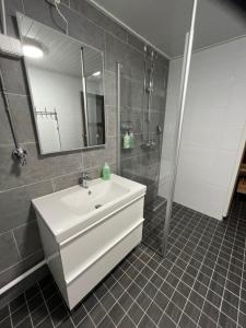 y baño con lavabo blanco y ducha. en Nice and cozy townhouse, en Rovaniemi