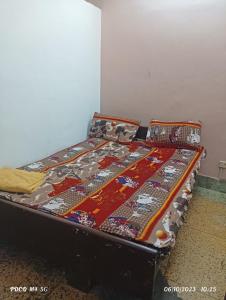 a bed with a quilt on it in a room at NAVRANG DELHI BACKPACKER in New Delhi
