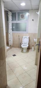 uma casa de banho com um WC e um chuveiro em Sharing motel rooms em Abu Dhabi