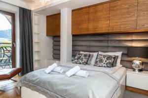 um quarto com uma cama grande e uma varanda em MOUNTAIN BASE Apartament Bellissimo em Zakopane