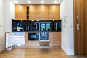 uma cozinha com armários de madeira e um frigorífico em MOUNTAIN BASE Apartament Bellissimo em Zakopane