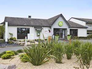 a white building with plants in front of it at Campanile Rennes Ouest Cleunay in Rennes