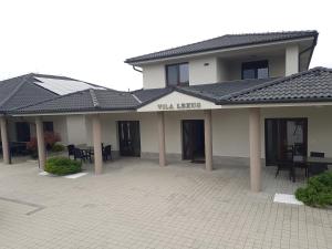 a building with a courtyard with tables and chairs at Vila Lexus in Veľký Meder