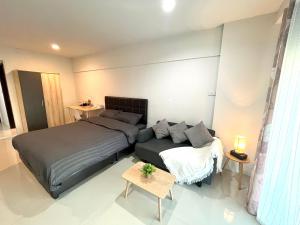 1 dormitorio con 2 camas y sofá en Maitree cozy room/Close to Nimman/Pool/Gym, en Chiang Mai