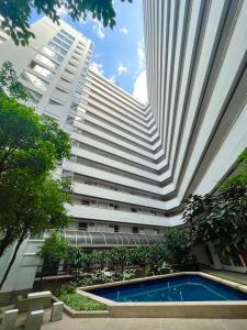 un edificio alto con piscina frente a un edificio en Maitree cozy room/Close to Nimman/Pool/Gym, en Chiang Mai