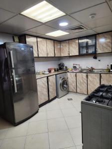 uma cozinha com um frigorífico e uma máquina de lavar roupa em Sharing motel rooms em Abu Dhabi