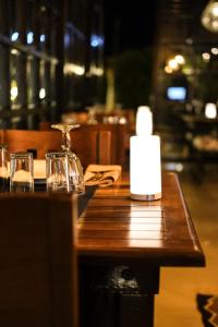 チェシメにあるRooms Smart Luxury Hotel & Beachの木製テーブル(キャンドルとグラス付)