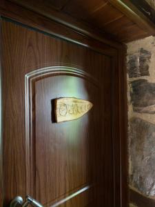 a wooden door with a sign on it at Suites Mouses in Palaios Agios Athanasios