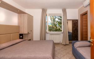 1 dormitorio con cama y ventana en Hotel Eura, en Marina di Massa