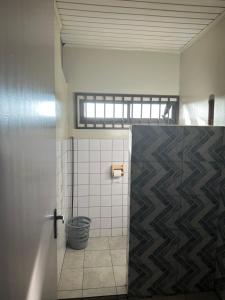 a bathroom with a tiled shower with a window at Tweederijweg Apartments in Paramaribo