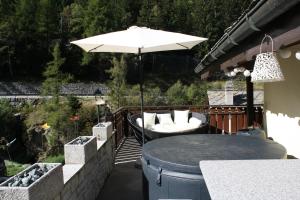 um pátio com uma mesa e um guarda-sol em Chalet Bodenbrücke em Eisten