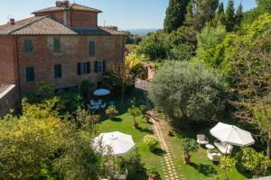 un jardín al aire libre con sombrillas y un edificio en Villa Vignacce - Boutique Country Resort, en Bettolle