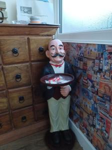 a statue of a man holding a plate of food at Falcon Towers in Stowmarket