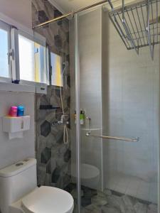 a bathroom with a glass shower with a toilet at ELLIE HOUSE in Xiaoliuqiu