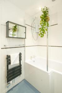 a bathroom with a tub and a sink and a mirror at Hollybobs in Leiston