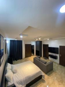 a large bedroom with a bed and a couch at 93 Homes and Residence (Shortlet Apartment in Abuja) in Abuja