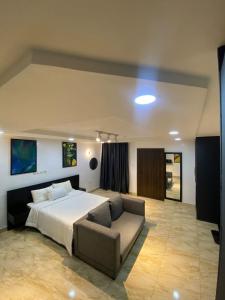 a large bedroom with a bed and a couch at 93 Homes and Residence (Shortlet Apartment in Abuja) in Abuja