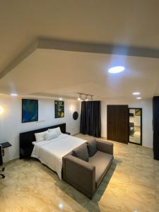 a large bedroom with a bed and a couch at 93 Homes and Residence (Shortlet Apartment in Abuja) in Abuja