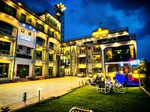 a group of people sitting in chairs outside of a building at Swat Hilton Hotel by Khan Familia in Swat