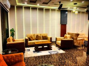 a living room with couches and chairs and a table at Swat Hilton Hotel by Khan Familia in Swat