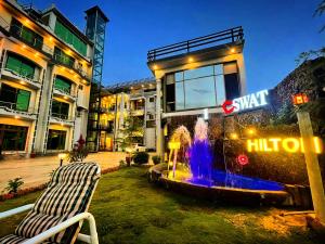 a building with a fountain in front of a building at Swat Hilton Hotel by Khan Familia in Swat