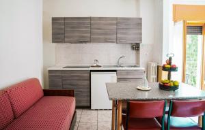 Residence Beau Sejour في آنتي-سان-أندريه: مطبخ مع أريكة حمراء وطاولة مطبخ