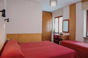 a bedroom with two beds and a desk and a mirror at Residence Beau Sejour in Antey-Saint-André
