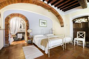 a bedroom with a bed and a brick wall at Villa Vignacce - Boutique Country Resort in Bettolle