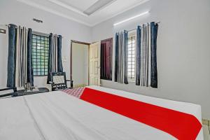 una camera con letto e finestre rosso e bianco di OYO Flagship Hornbill Residency a Alleppey