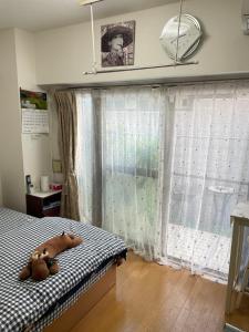 a bedroom with a bed with two teddy bears on it at 桜宿-ダブルベッドの小さなガーデンルーム in Tokyo