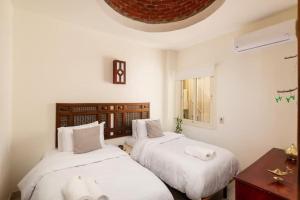 a bedroom with two beds with white pillows at Makadi Heights Elite Worldwide Residences - Hurghada, Egypt in Hurghada